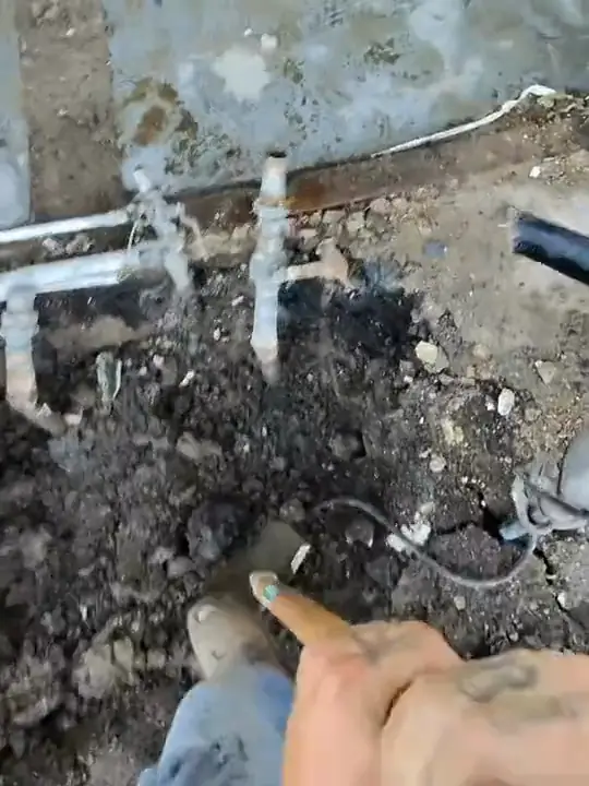 Through Jacob's glasses: water lines exposed in a dig beside a house